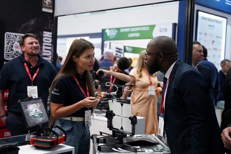 Exhibitor and delegates discussing technology on the exhibition floor at Mining Indaba